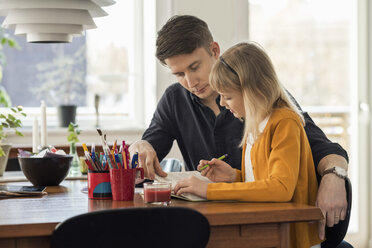 Father assisting daughter in homework at home - MASF03177