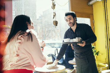 Barista bedient eine Kundin in einem Café - MASF03201