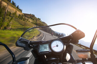 Ausgeschnittenes Bild eines Motorrads, das auf einer Bergstraße gegen den klaren Himmel fährt - CAVF36637