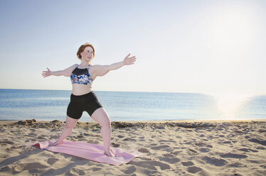 Frau übt Yoga am Strand gegen den klaren Himmel in voller Länge - CAVF36986