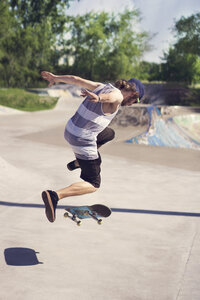 Junger Mann macht Skateboard-Trick auf Rampe - CAVF36993