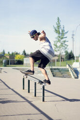 Young man skateboarding on railing - CAVF36997