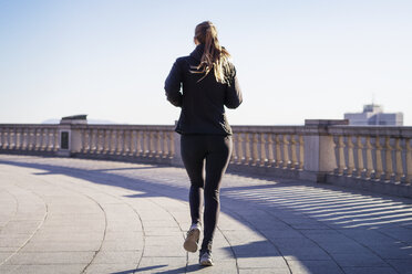 Rear view of young woman running - CAVF37005