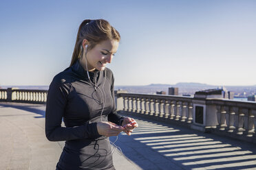 Young woman with headphones using smartphone - CAVF37006