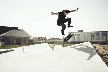 Junger Mann vollführt Stunts auf dem Skateboard - CAVF37013