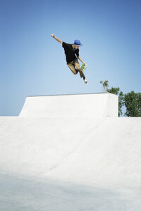 Junger Mann vollführt Stunts auf dem Skateboard - CAVF37016