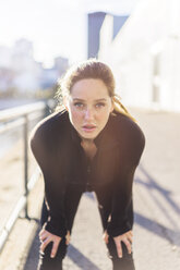 Portrait of tired woman bending by railing in city - CAVF37028