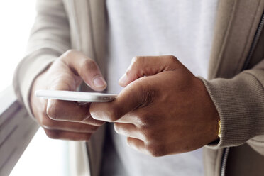 Midsection of businessman using smart phone in creative office - CAVF37110