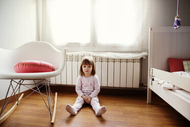 Nachdenkliches Mädchen sitzt auf Hartholzboden im Schlafzimmer - CAVF37170