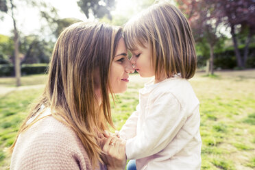 Side view of affectionate mother and daughter head to head in park - CAVF37179