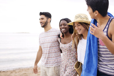 Glückliche Freunde, die im Urlaub am Strand spazieren gehen - CAVF37194