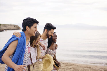 Fröhliche Freunde, die im Urlaub am Strand spazieren gehen - CAVF37196