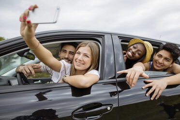 Glückliche männliche und weibliche Freunde, die ein Selfie machen, während sie im Auto sitzen - CAVF37208