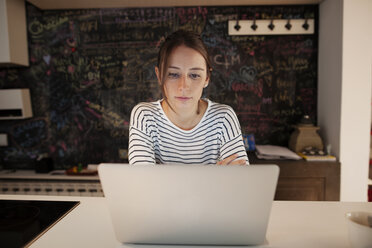 Konzentrierte Frau mit Laptop am Tisch - CAVF37285