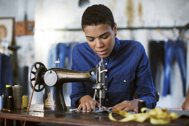Modedesignerin bei der Arbeit mit einer Nähmaschine in einer Werkstatt - CAVF37308