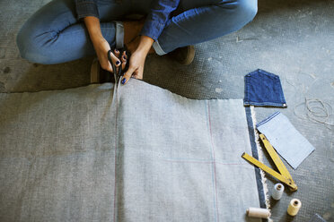 Tiefschnitt eines Modedesigners beim Zuschneiden von Stoffen in der Werkstatt - CAVF37314