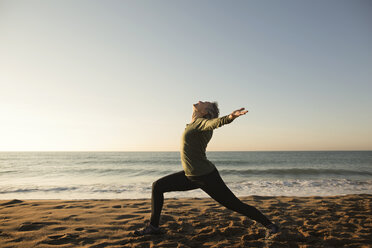 Seitenansicht einer Frau beim Yoga am Strand gegen den klaren Himmel - CAVF37344