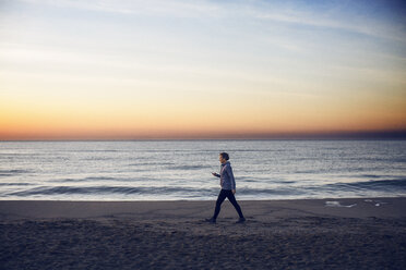 Full length of woman walking at beach against sky - CAVF37364