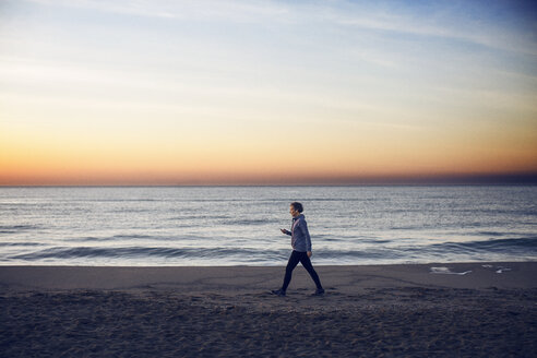 Frau in voller Länge am Strand spazierend gegen den Himmel - CAVF37364