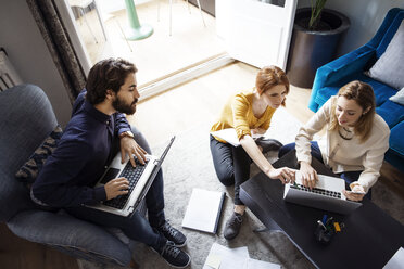 Hochformatige Ansicht von kreativen Menschen mit Laptops im Büro - CAVF37412