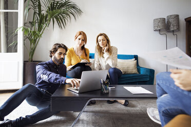 Geschäftsleute benutzen einen Laptop während einer Besprechung im Kreativbüro - CAVF37414