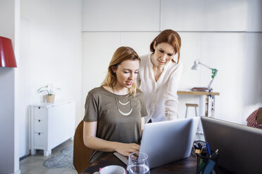 Geschäftsfrauen arbeiten an einem Laptop im Kreativbüro - CAVF37423