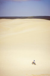 Teenager-Mädchen fährt Fahrrad in der Wüste - CAVF37477