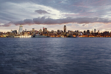 Sea and cityscape against cloudy sky during sunset - CAVF37486