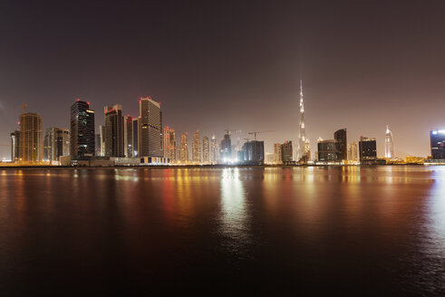 Beleuchtete Stadtlandschaft und der Dubai Creek gegen den klaren Himmel in der Abenddämmerung - CAVF37498