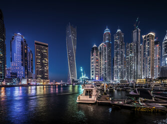 River and illuminated cityscape against blue sky at night - CAVF37501