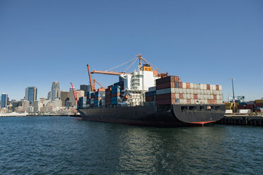 Containerschiff vor einem Handelsdock vor blauem Himmel - CAVF37504