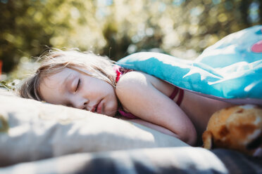 Side view of girl sleeping on blanket at campsite - CAVF37652