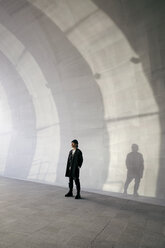 Full length of thoughtful man standing in tunnel - CAVF37739