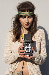 Junge Frau fotografiert durch eine alte Kamera im Freien - CAVF37773