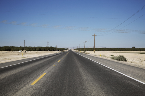 Autobahn auf Landschaft gegen klaren blauen Himmel, lizenzfreies Stockfoto
