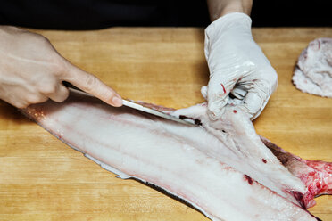 Nahaufnahme eines Kochs, der Fisch auf einem Schneidebrett schneidet - CAVF37794