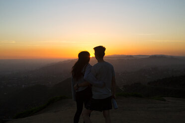 Rückansicht eines auf einem Berg stehenden Paares gegen den Himmel bei Sonnenuntergang - CAVF37807