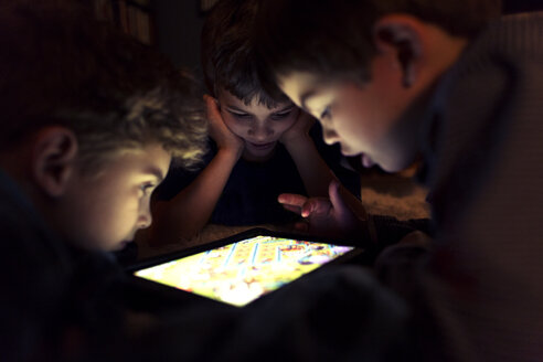 Geschwister spielen zu Hause ein Spiel auf einem Tablet-Computer - CAVF37835