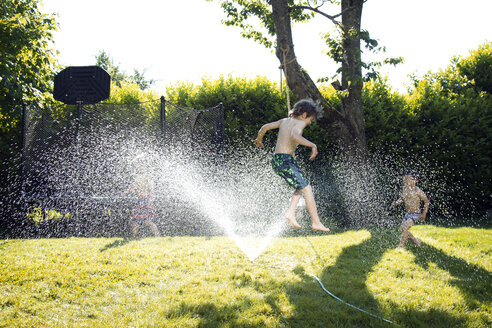 Jungen spielen im Rasensprenger - CAVF37913