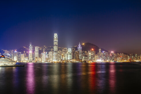 Victoria harbour against illuminated Two International Finance Center and buildings in city at night - CAVF37914