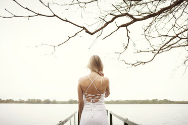 Junge Frau in weißem Kleid auf einem Steg - CAVF37922