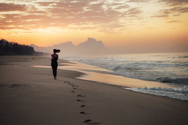 Junge Frau läuft am Strand - CAVF37924