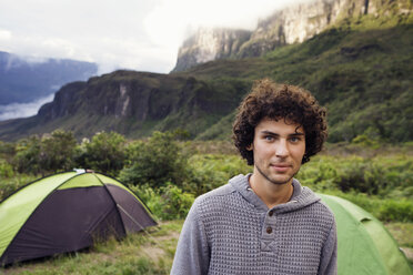 Porträt eines selbstbewussten Mannes auf einem Campingplatz in den Bergen - CAVF38000