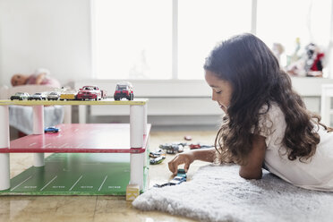 Seitenansicht eines Mädchens, das mit einem Spielzeugauto in einer Kindertagesstätte spielt - MASF03255