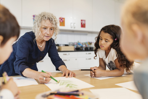 Senior teacher with students in drawing class stock photo