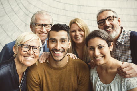 Ein Team von selbstbewussten Geschäftsleuten lächelt im Büro, lizenzfreies Stockfoto