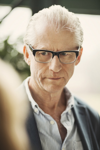 Seriöser Geschäftsmann mit Brille im Büro, lizenzfreies Stockfoto