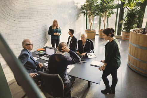 Team von kreativen Geschäftsleuten, die am Tisch im Büro diskutieren - MASF03279