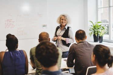 Smiling teacher talking to multi-ethnic students at language class - MASF03298