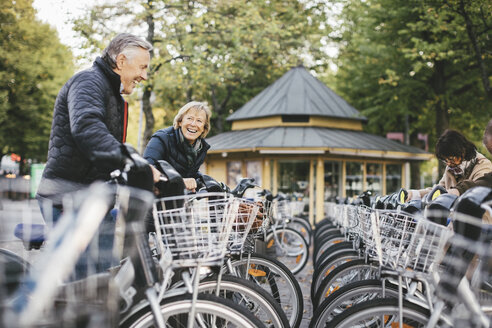 Ältere Menschen nehmen Leihfahrräder am Parkplatz - MASF03303